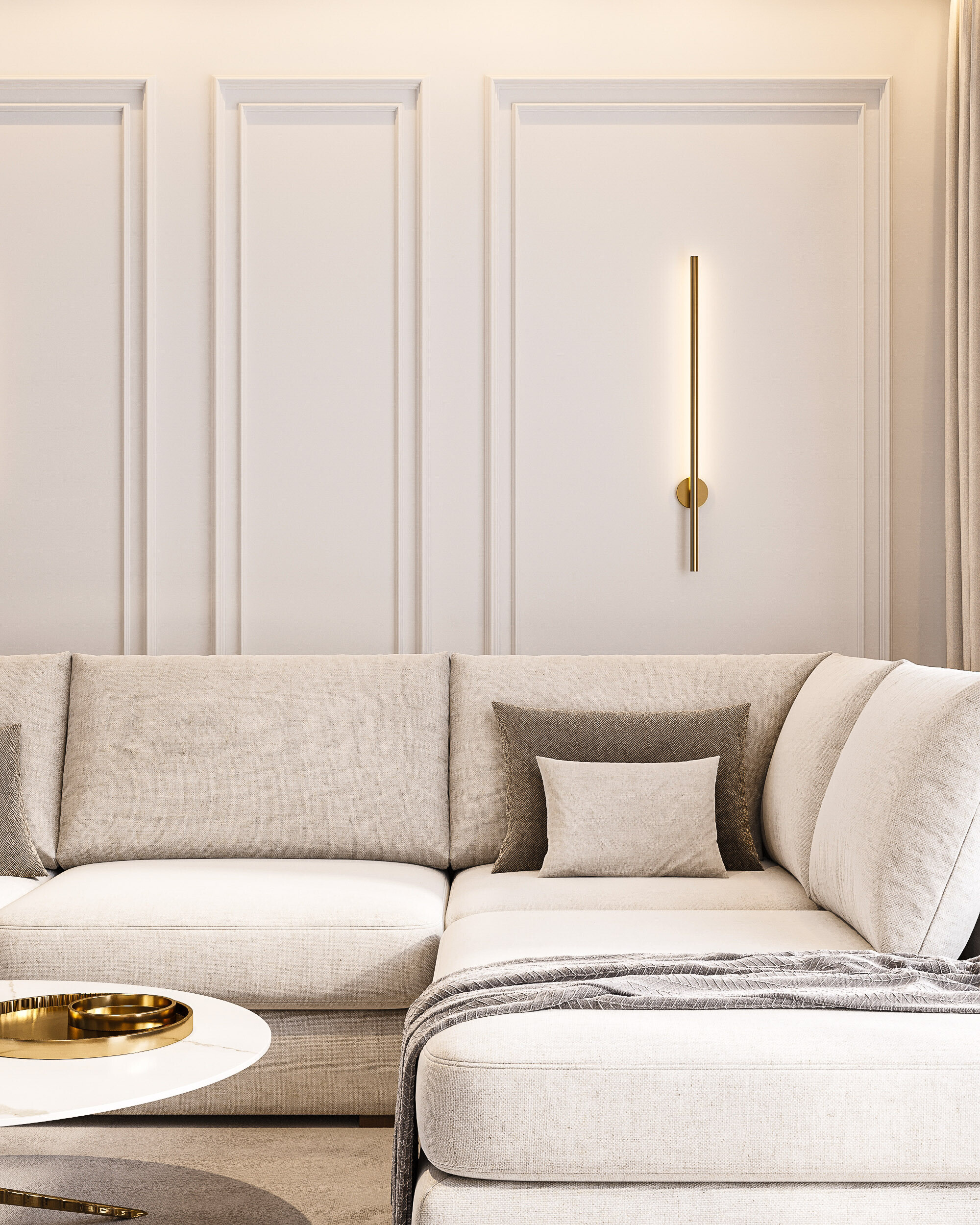 Klasyczna strefa wypoczynkowa w Gorlicach - FILAR MY PROJECT Jasna sofa z poduszkami na tle ściany ze sztukaterią i smukłym złotym kinkietem, Gorlice, FILAR MY PROJECT.
